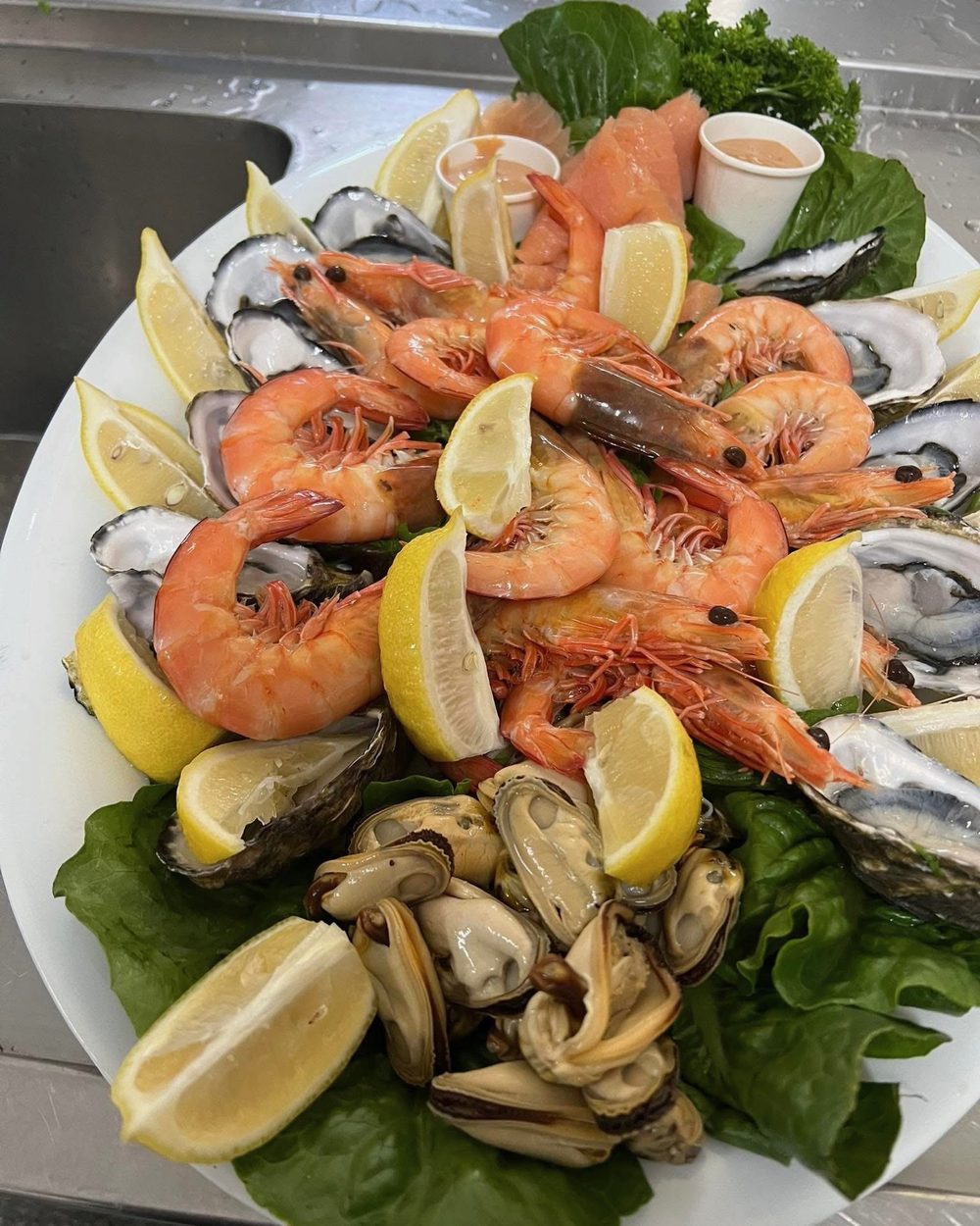 Gourmet seafood platter with fresh prawns, oysters and lemon